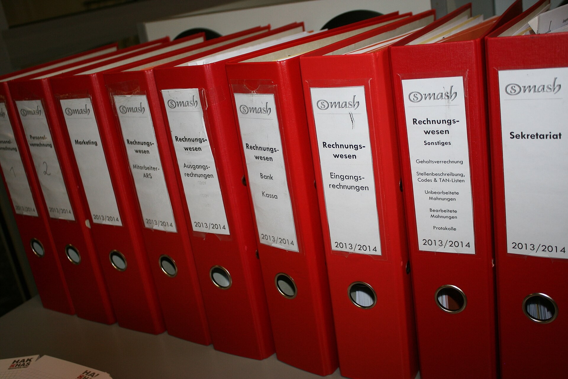 Dossiers administratifs classés dans des chemises rouges.